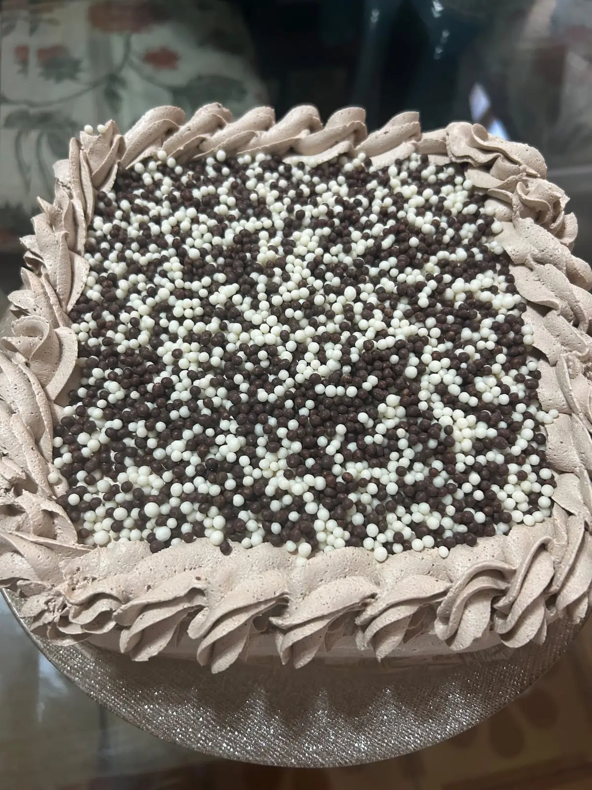 Bolo de aniversário com borda confeitada e confeitos brancos e escuros, da Sant'Anna