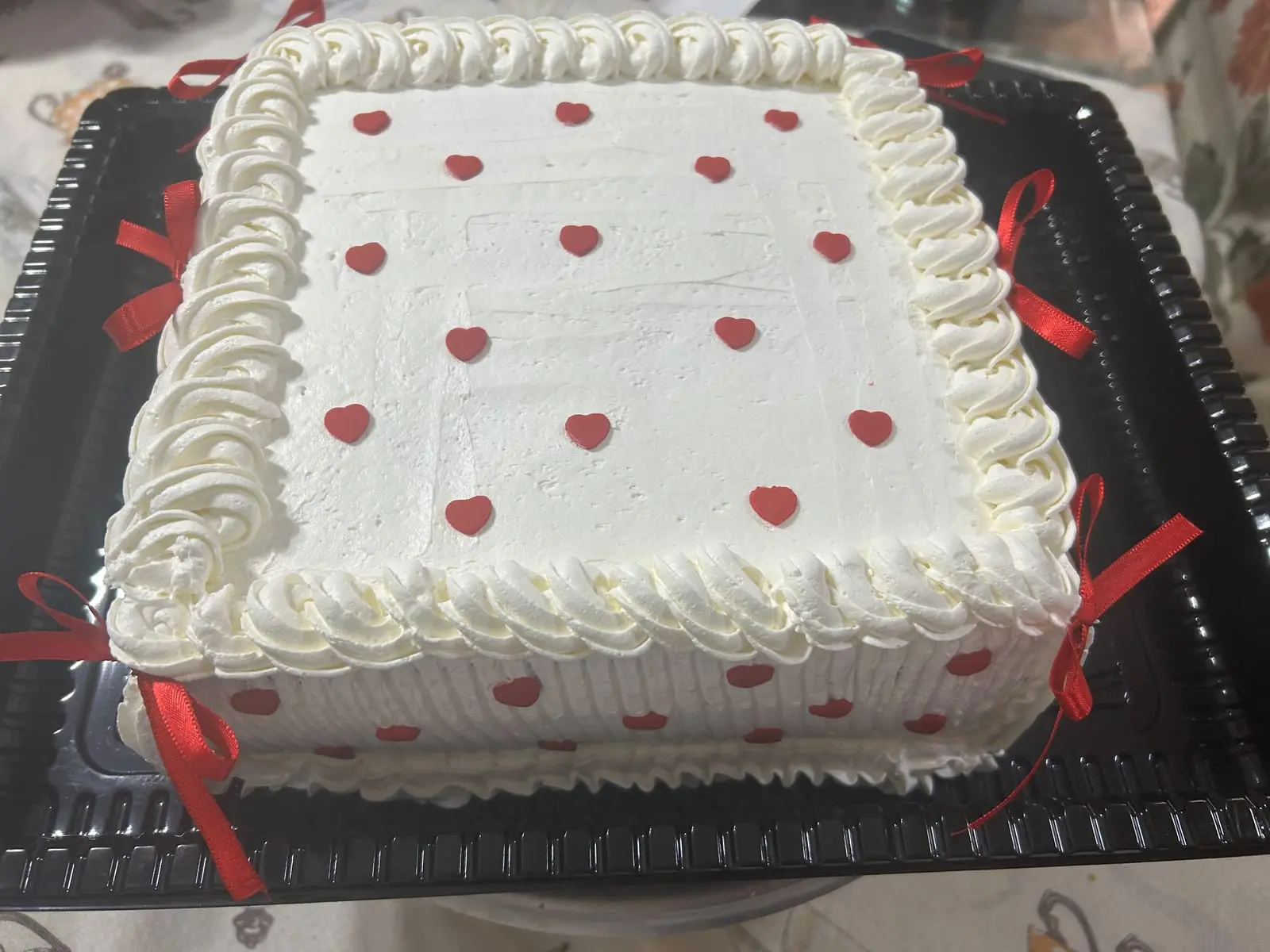 Bolo branco com corações vermelhos e laços de fita, da Sant'Anna