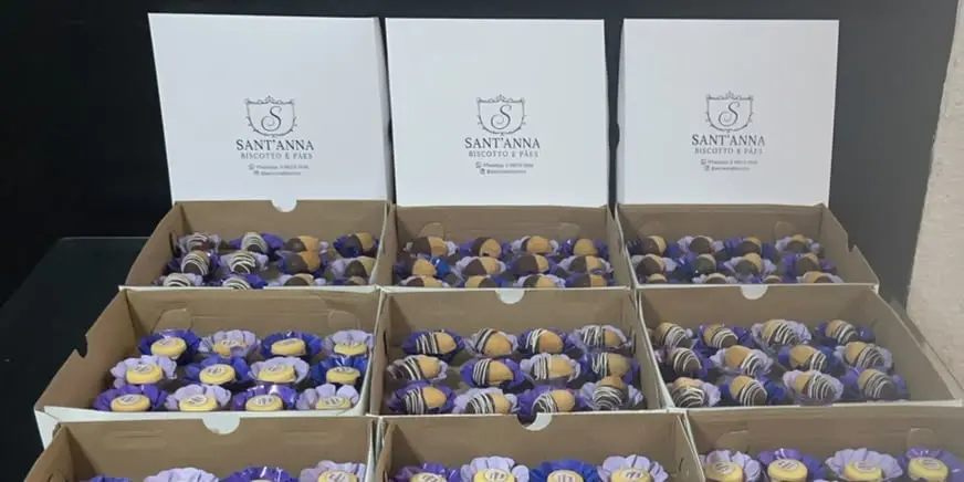 Caixas da Sant'Anna Biscotto e Pães atrás das bandejas de oreshki de Nutella e casadinhos de limão de uma festa de 15 anos